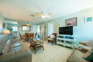 Living area with power recliners on couch and loveseat. New 50" smart TV