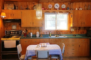 a full kitchen with stove, oven, fridge, microwave, toaster and teapot