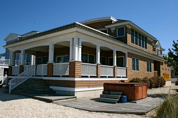 View of back of house including hot tub and wrap around porch, bay is behind me