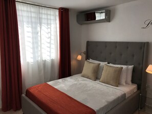Habitación con cama Queen que permite acomodar a dos personas, incluye AC.