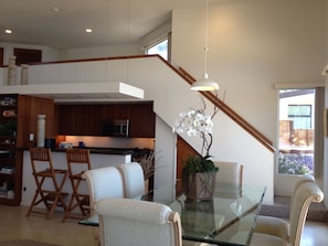 Gourmet kitchen, bar area, dining room, and stairs to the loft area