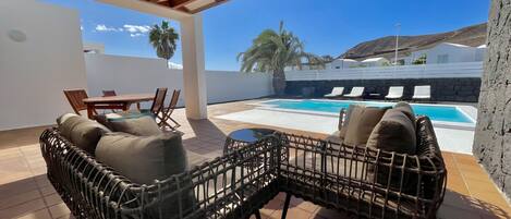 Large terrace with outdoor furniture and private pool heated by a heat pump