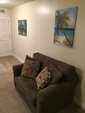 Living room with sitting chair and flat screen television.