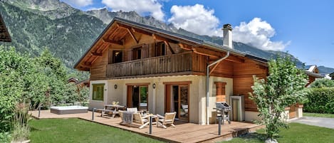 Grande terrasse avec mobilier d'extérieur et barbecue