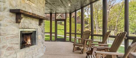Screened in patio on the lower level with a wood burning fireplace