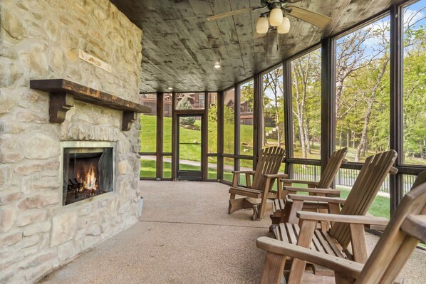 Screened in patio on the lower level with a wood burning fireplace