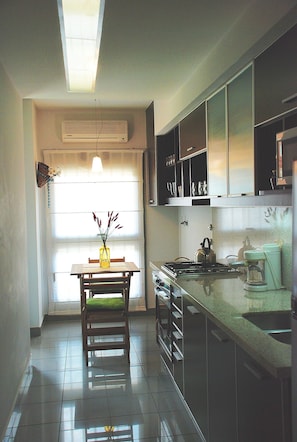 Luminous kitchen with table for 2 people and access to balcony