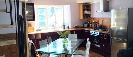 Spacious light and airy open plan kitchen diner living room with exposed beams 