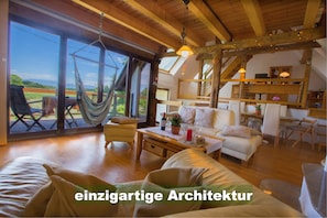 Living room with a magnificent view over green meadows and fields