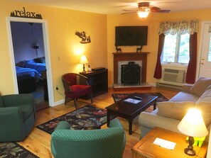 Large family room with gas stove, flat screen TV, and balcony access.