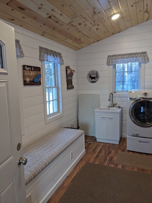 entry room with laundry sink washer dryer and coat storage