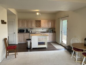 Kitchen with utility room behind white door. 