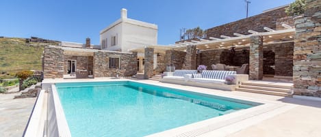 The pool outdoor seating and dining area and a view of the villa