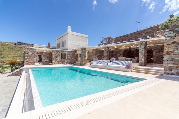 The pool outdoor seating and dining area and a view of the villa