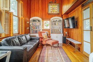 North-facing wall of living room with bookshelves, TV, stained glass windows