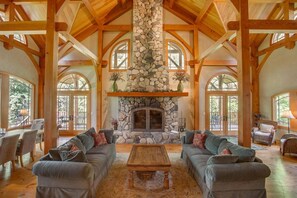 The grand hall features a cathedral ceiling and river rock fireplace