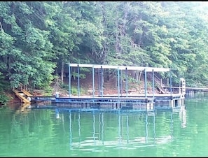 The covered floating dock with boat slip and swimming deck.