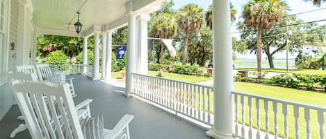 The expansive front porch has plenty of seating, from traditional southern rockers to a porch swing and a dining table. With ceiling fans and a gentle breeze from the bay, it's a wonderful place to gather with friends, relax with a good book, or nap.