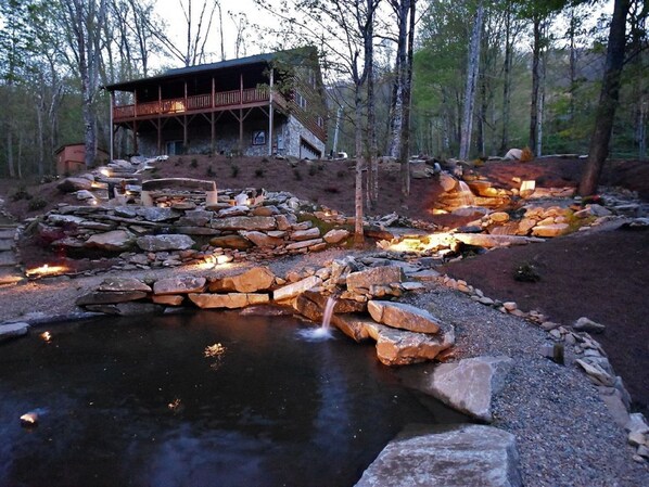 Waterfall and fire pit lit up at night