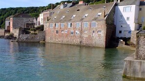 View of cottage from beach with tide in