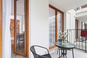 Furnished balcony with green surroundings. 