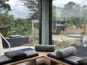 View from the indoor sunset daybed area out to the spa, sauna and yoga deck