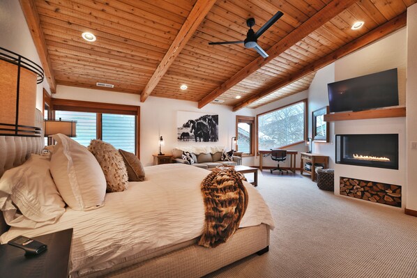 Upper-level master bedroom with fireplace, work area, and reading nook 