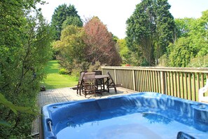 The hot tub and deck in the large garden. 