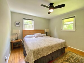 King bed with memory foam pad, ceiling fan, room darkening shades, and Roku TV. 