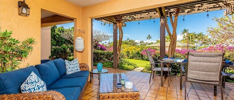 Everything you need to live outdoors --- an outdoor sofa and eating area.