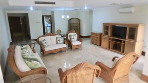 Living room facing kitchen and round glass dining table