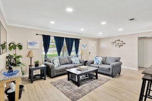 The living room has a queen sleeper sofa bed, room darkening shades, and a large Smart TV.