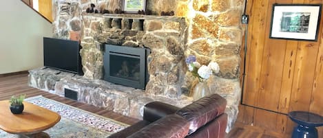 Large stone fireplace in great room with gas insert on timer