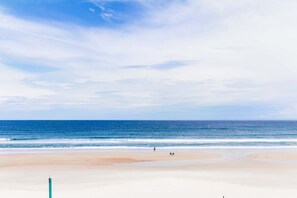 On a gorgeous, wide, sandy beach with access to the beach from the pool area.