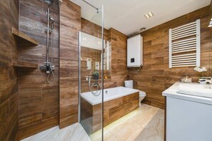 Comfortable bathroom with bathtub and shower.
