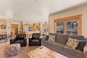 Living area featuring a gas fireplace, mounted flat-screen TV, queen sleeper sofa, and balcony access.