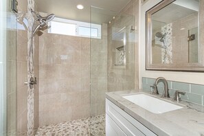 Pebble decor and frameless glass shower, glass backsplash, all new fixtures!