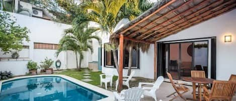 Private backyard swimming pool with palapa patio and beautiful palms