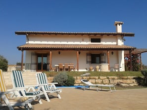 Veranda in front of the pool with umbrellas and sun-chairs