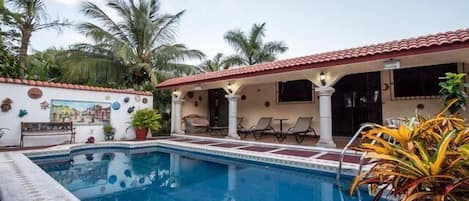 Pool area and patio are furnished with table, chairs, hammock and loungers