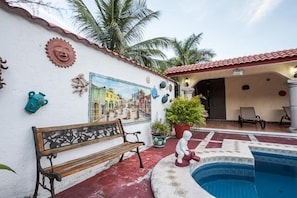 Pool/ patio area is surrounded by a beautiful tropical garden