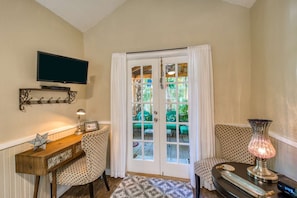 A hurricane lamp, tin decor and beadboard give an old time feel to the cabin.  A mounted flatscreen TV is viewable from the TV and sofa.