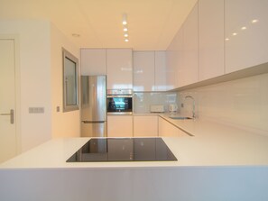 Cocina abierta totalmente equipada con líneas ordenadas.