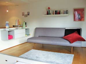 Das Sofa auf dem Podest kann zum Schlafen (120cm x 200cm)umgeklappt werden.