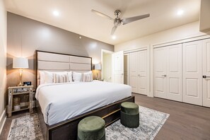 Spacious master bedroom with a king bed, ensuite bath, and designer built-in closets. Equipped with nightstands, lamps, hangers, luggage racks, alarm clock, white noise machine, and a 55” Samsung Smart 4K TV for streaming and DIRECTV Entertainment.