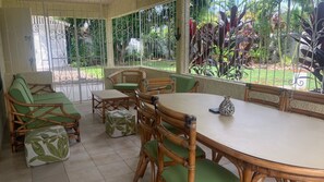 Large patio with outdoor dining and view of yard