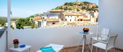 Terraza con  toldo, tumbonas, sillas y mesa con vistas al Castillo de Capdepera