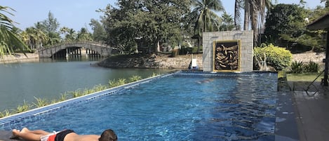 Private swimming pool behind the villa by the river.