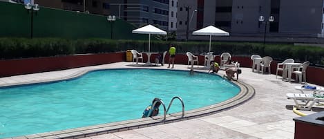 Banho de sol e piscina com deque próximo para um lanche ou drinque.