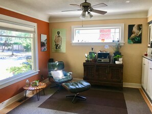 Comfy living w/ Herman Miller, Record Player, pleasant view, tree-lined street.